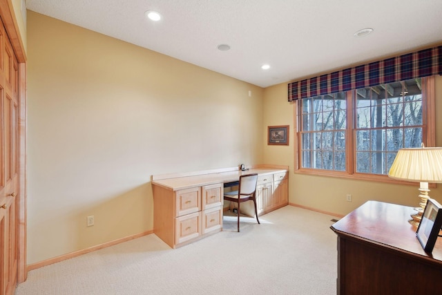 office space featuring built in desk and light colored carpet