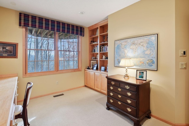 carpeted office space with built in shelves