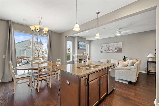 kitchen featuring decorative light fixtures, dishwasher, sink, plenty of natural light, and a center island with sink