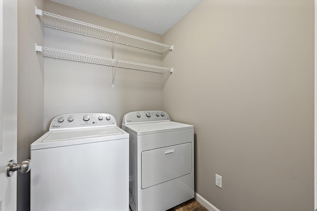 washroom with washing machine and dryer and a textured ceiling