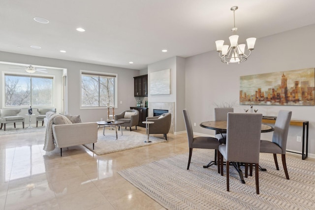 dining space with an inviting chandelier and a tiled fireplace