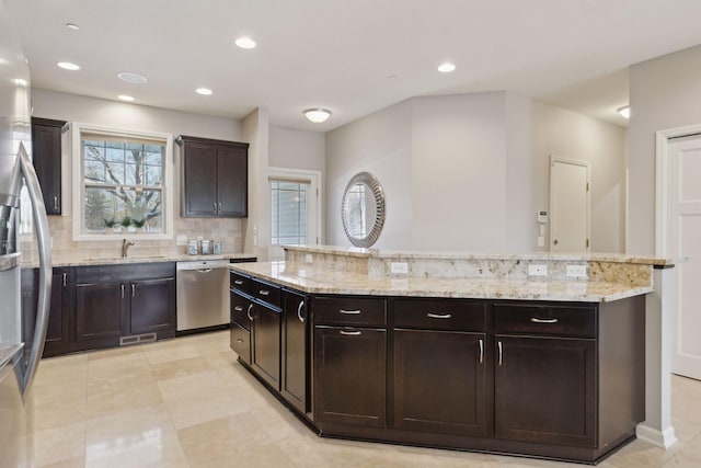 kitchen featuring decorative backsplash, sink, dark brown cabinetry, and stainless steel appliances