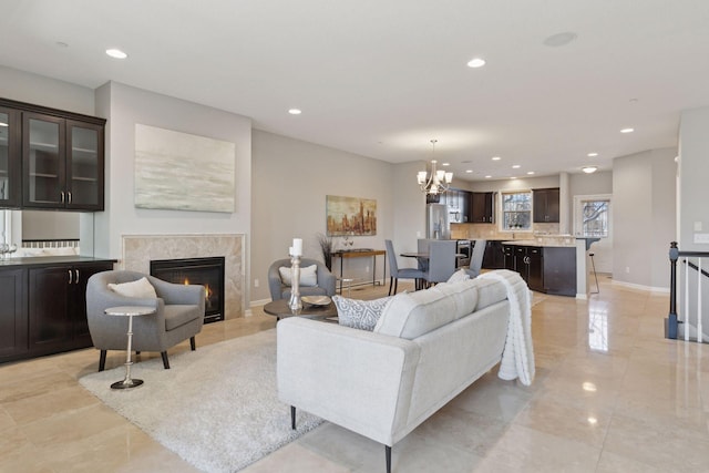 living room featuring a tiled fireplace and a chandelier