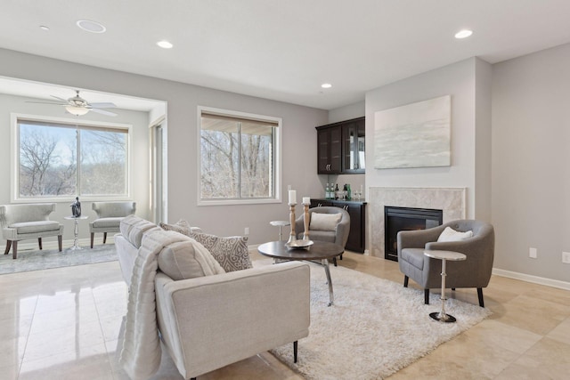 living room featuring ceiling fan, a fireplace, and plenty of natural light