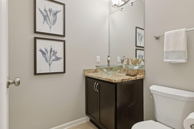 bathroom featuring toilet, vanity, and tile patterned flooring