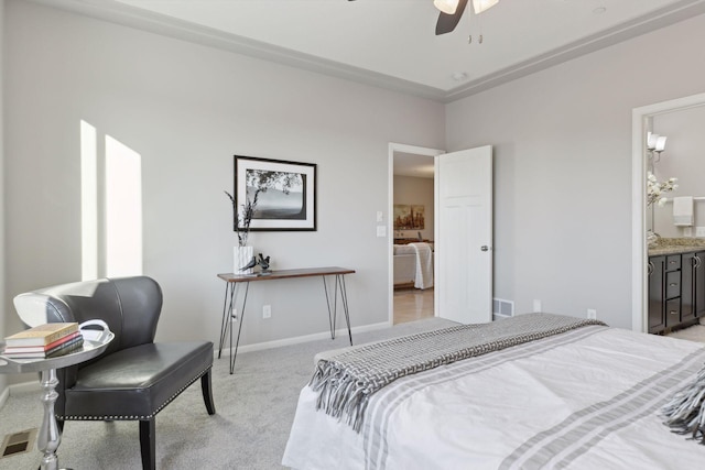 bedroom with light carpet, ceiling fan, and ensuite bath