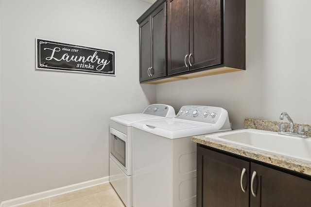 washroom featuring sink, light tile patterned flooring, independent washer and dryer, and cabinets