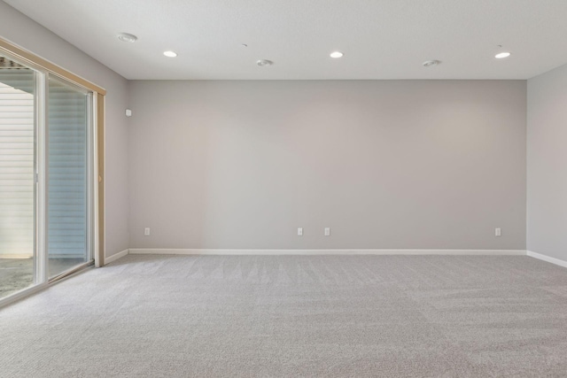 empty room featuring a wealth of natural light and light colored carpet