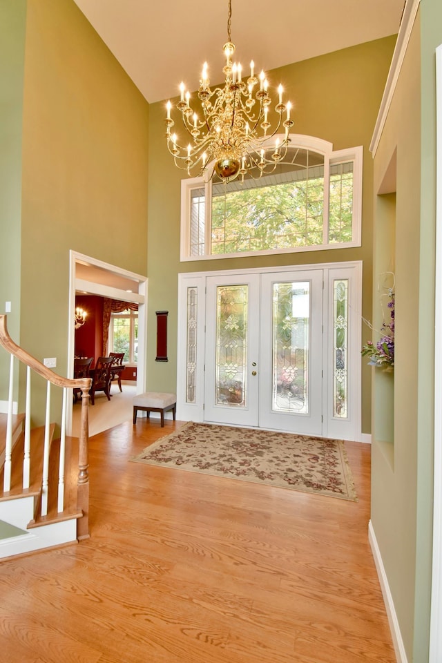 foyer featuring a chandelier, a high ceiling, a wealth of natural light, and hardwood / wood-style floors