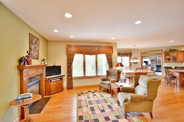 living room featuring a high end fireplace and light wood-type flooring