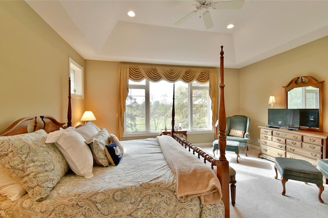 bedroom featuring a tray ceiling, ceiling fan, and light colored carpet