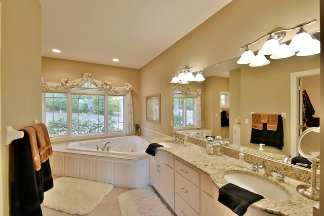 bathroom featuring tile patterned flooring, vanity, and a tub to relax in