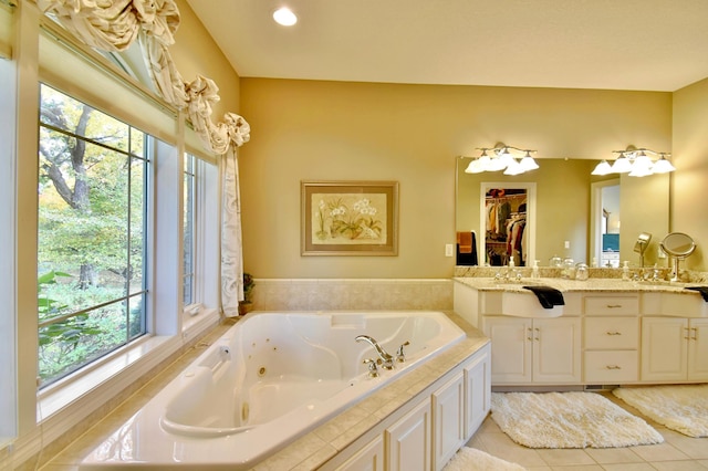 bathroom featuring tile patterned flooring, vanity, and a tub to relax in