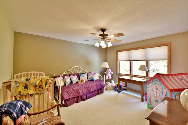 bedroom with ceiling fan, carpet, and a textured ceiling