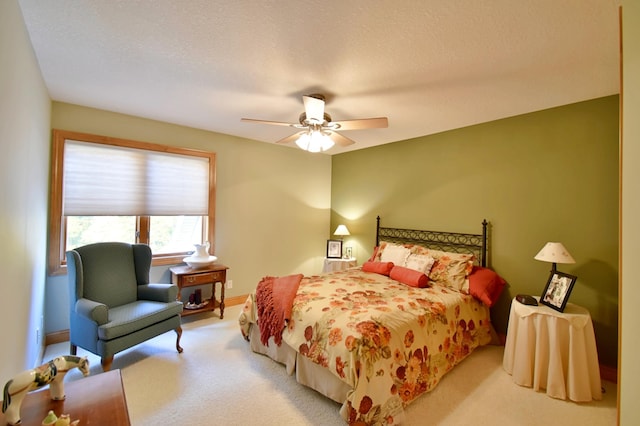 bedroom with ceiling fan, light colored carpet, and a textured ceiling