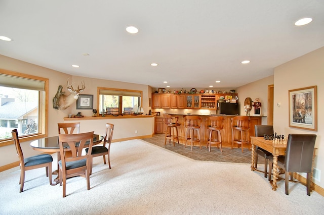 carpeted dining area with indoor bar