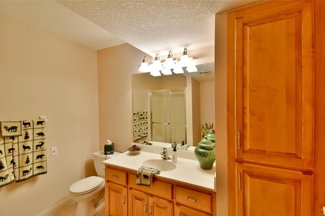 bathroom with vanity, tile patterned floors, toilet, a textured ceiling, and walk in shower