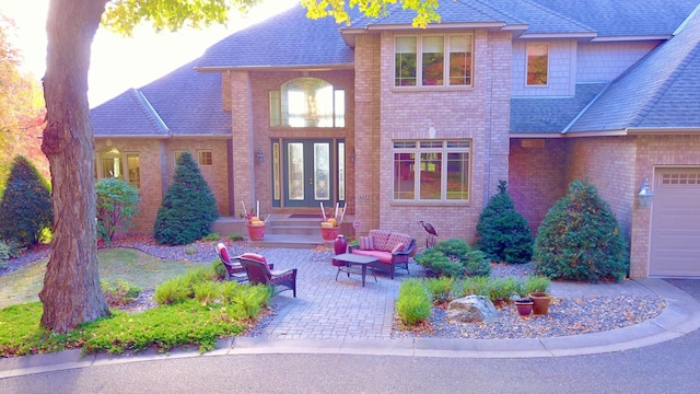 view of front facade featuring a garage, a patio, and french doors