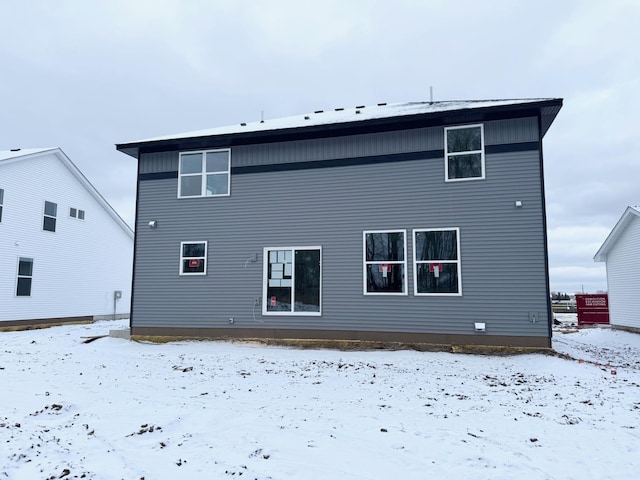 view of snow covered back of property