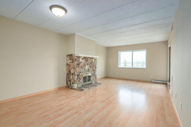 unfurnished living room with a fireplace, hardwood / wood-style floors, and a baseboard radiator