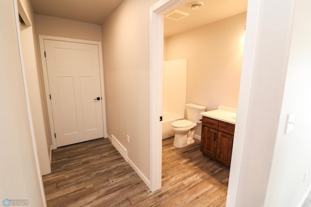 bathroom with hardwood / wood-style floors, vanity, and toilet