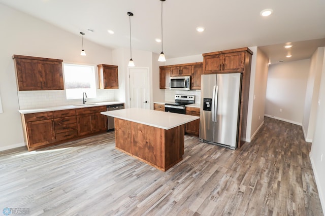 kitchen with backsplash, stainless steel appliances, vaulted ceiling, a kitchen island, and hanging light fixtures