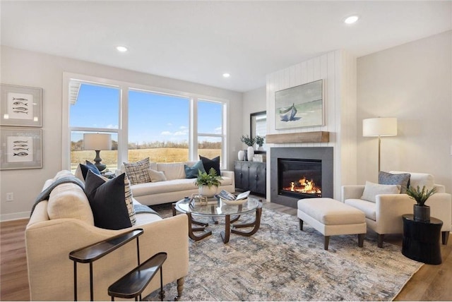 living room featuring recessed lighting, baseboards, wood finished floors, and a fireplace
