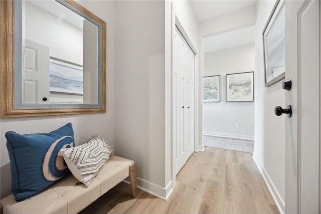 hallway featuring baseboards and light wood-style floors