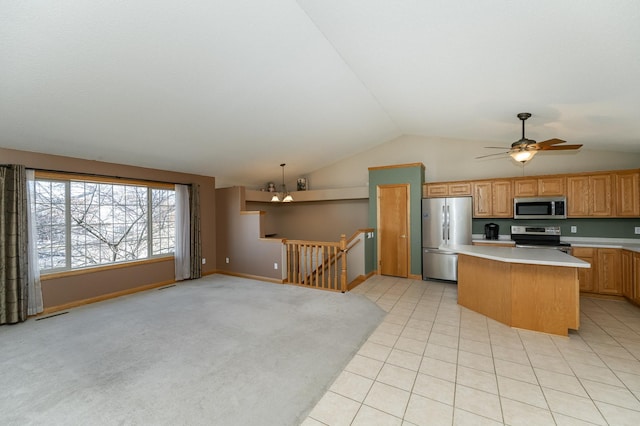 kitchen with stainless steel appliances, light tile patterned floors, decorative light fixtures, a center island, and lofted ceiling