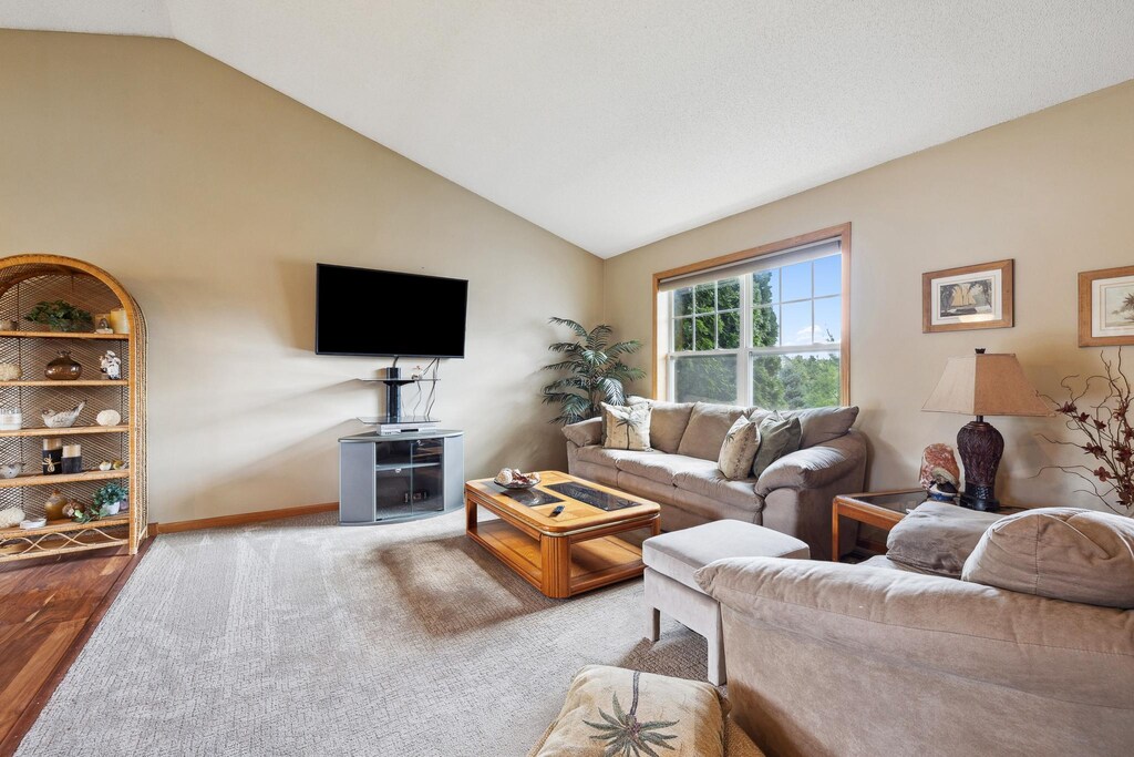 carpeted living room featuring lofted ceiling