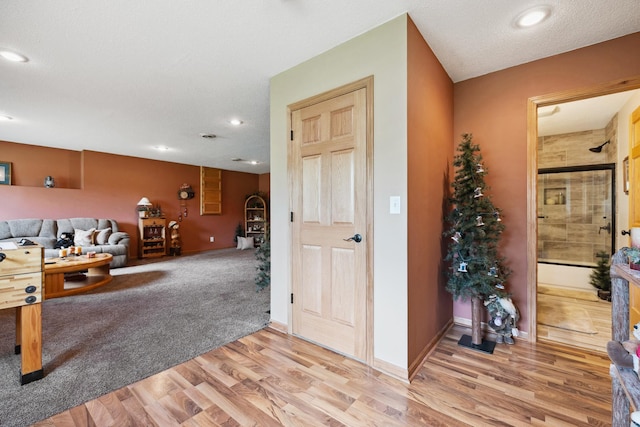 rec room featuring a textured ceiling and light wood-type flooring