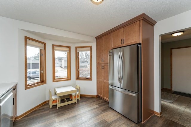 kitchen with a healthy amount of sunlight, dark wood-style floors, and stainless steel appliances