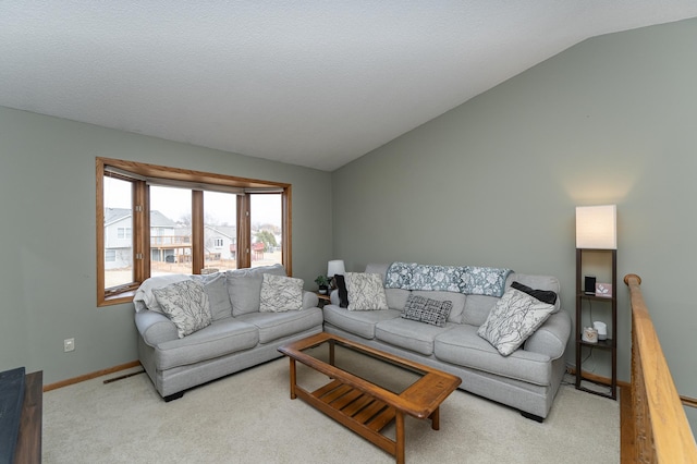 living room featuring lofted ceiling, carpet, baseboards, and a textured ceiling