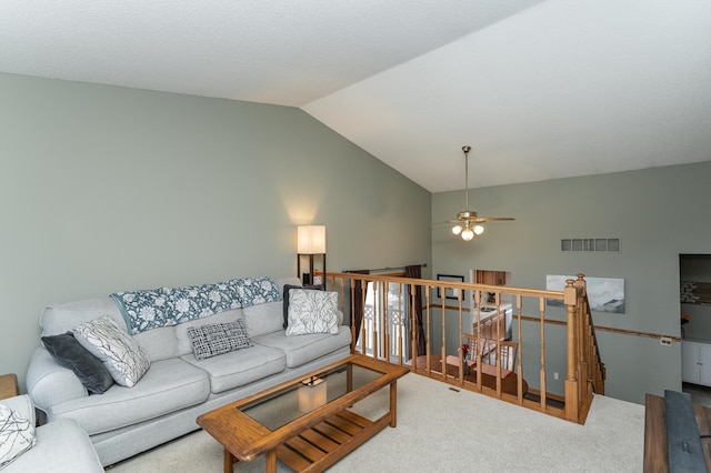 living area featuring carpet floors, ceiling fan, visible vents, and vaulted ceiling