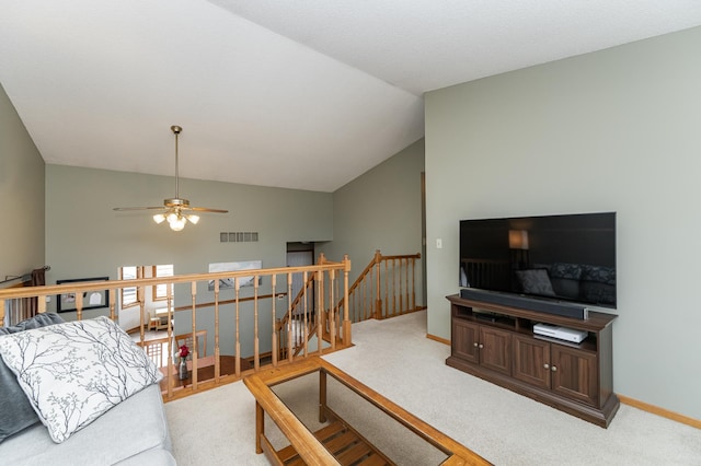 living room featuring carpet floors, a ceiling fan, visible vents, vaulted ceiling, and baseboards