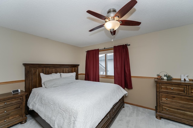 bedroom with light carpet, ceiling fan, a textured ceiling, and baseboards