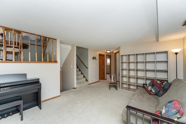 living area with carpet floors, a textured ceiling, baseboards, and stairs