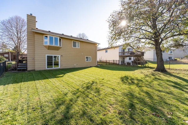 rear view of house with stairs, a deck, a lawn, and a fenced backyard