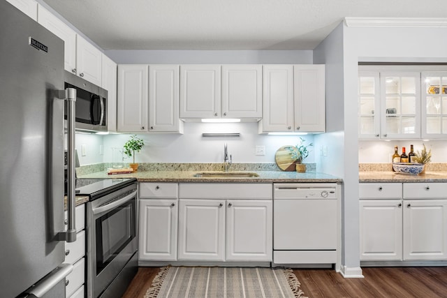 kitchen with sink, white cabinets, ornamental molding, dark hardwood / wood-style flooring, and stainless steel appliances