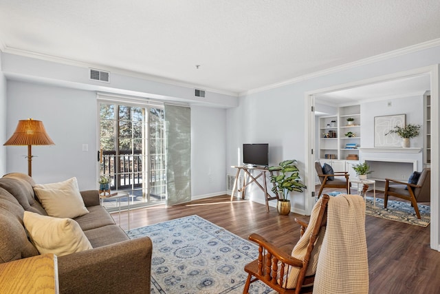 living room with built in shelves, dark hardwood / wood-style floors, and crown molding