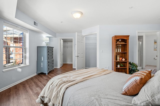 bedroom featuring hardwood / wood-style floors, a closet, and a spacious closet