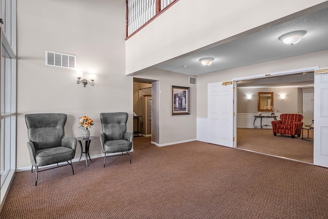 living area featuring a textured ceiling, carpet floors, and a barn door