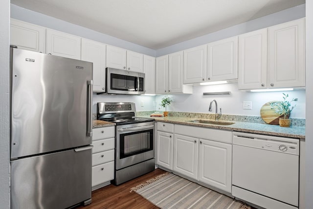 kitchen featuring stainless steel appliances, a sink, and white cabinetry