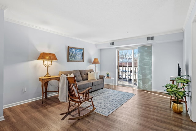 living area featuring ornamental molding, wood finished floors, and visible vents