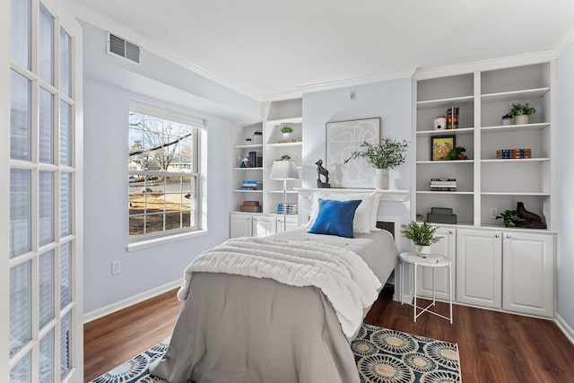 bedroom featuring baseboards, dark wood-type flooring, visible vents, and crown molding