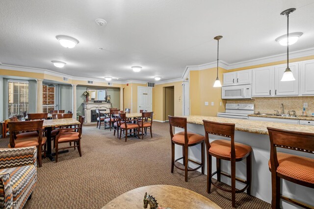 1350 Douglas Dr N Unit 105, Golden Valley, MN 55422 - kitchen with white appliances, a breakfast bar area, carpet floors, pendant lighting, and crown molding