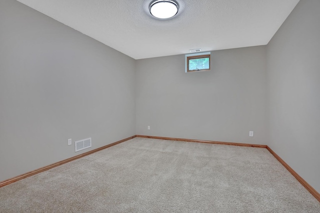 carpeted spare room with a textured ceiling