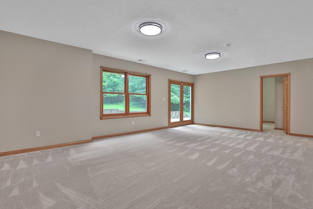 carpeted empty room with a textured ceiling