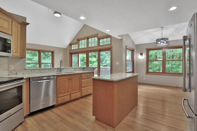 kitchen featuring light stone countertops, appliances with stainless steel finishes, pendant lighting, and sink