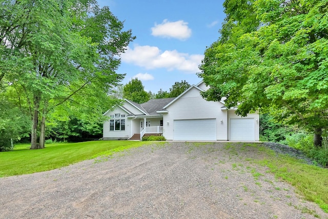 view of front of house with covered porch, a garage, and a front yard